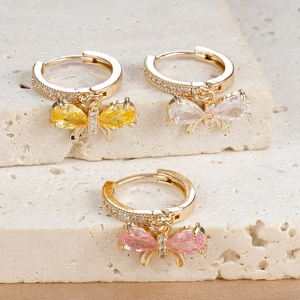 Detailed view of colorful zircon butterfly hoop earrings on natural stone displays