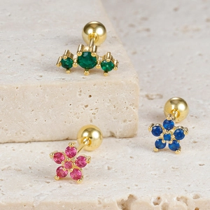 Detailed macro view of bow-knot stud earrings with colorful cubic zirconia and screw backs