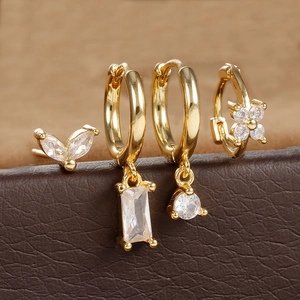 Macro view of a 4-piece gold plated earring set with marquise and floral zircon details