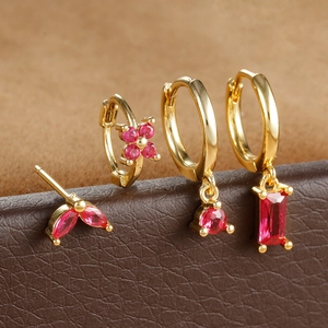 Detail of 4-piece gold earring set with marquise stones and fuchsia zircon pendants