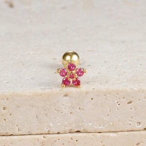 Detailed close-up of a flower stud earring with pink gemstones and gold metal base