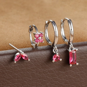 Macro shot of silver earring set featuring deep pink zircon stones in various cuts