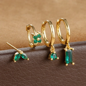 Detailed macro view of gold-plated earring set featuring marquise-cut green zircon stones