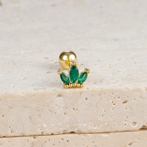 Macro view of gold crown stud earring with marquise green zircon and screw ball back
