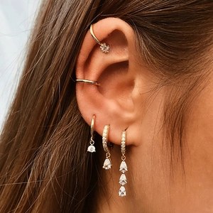 Gros plan de boucles d'oreilles s925 dorées avec zircons en forme d'étoile et de poire