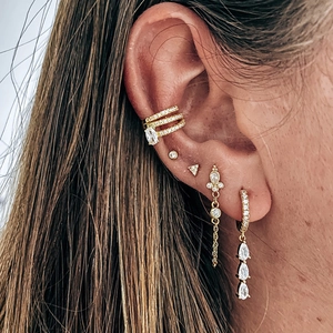 Détail de boucles d'oreilles dorées avec zircons clairs et pendentifs en forme de goutte