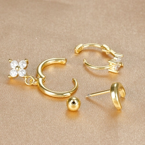 S925 silver gold-plated earring set with zircon flower charms on champagne silk background
