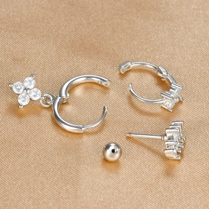 Detail of silver-toned star and moon earring set with sparkling zircons on gold silk fabric