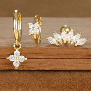 Macro shot of gold-plated celestial earrings set with sparkling zircon on dark wood