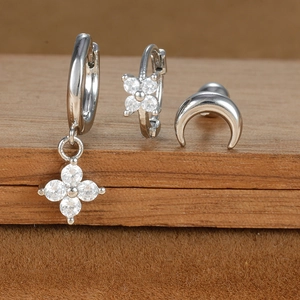 Detailed macro view of three-piece silver stud earring set with moon and zircon floral motifs