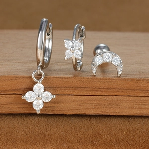 Detail of S925 silver earrings set with zircon stars and moon on a wooden stand
