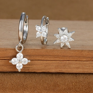 Detailed macro of silver star and flower earrings set with shimmering zircon stones
