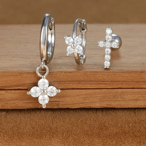 Detailed macro shot of silver zircon star and moon earring set on a wooden display