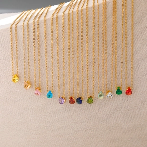 Vue détaillée de 12 pendentifs en zircone en forme de poire sur des chaînes dorées