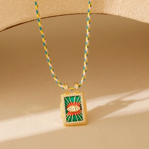 Détail d'un pendentif Tarot Mauvais Œil avec cordon tressé coloré et oxydes de zirconium