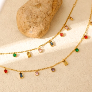 Détail de collier à franges de zircons multicolores sur une chaîne en acier titane doré