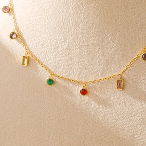 Détail de la chaîne plaquée or 18K avec des breloques en zircon coloré effet arc-en-ciel