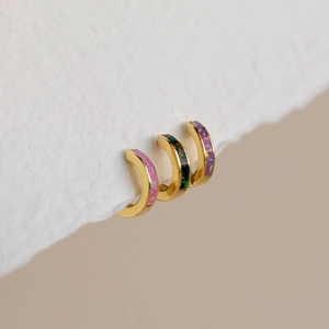 Makroaufnahme minimalistischer Goldohrringe mit bunten Opal-Inlay-Texturen