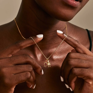 Elegant gold necklace featuring boy and girl pendants with red and white cubic zirconia stones