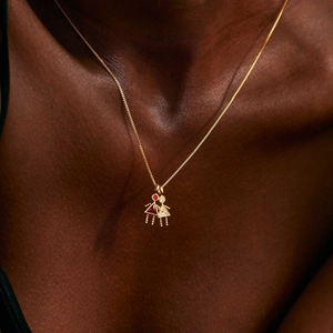 Detail of 18K gold girl pendants with red and white triangle cubic zirconia on model neck