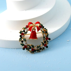 Detail of Christmas wreath brooch with enamel leaves, red bell, and sparkling rhinestones