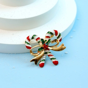 Detail of Christmas candy cane brooch with red crystal and festive enamel finish