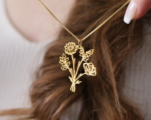 Gros plan d'un collier plaqué or avec un pendentif bouquet de fleurs évidé détaillé