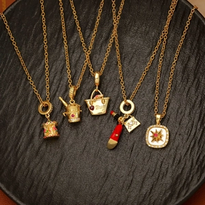Elegant gold necklaces with colorful carousel and luxury pendant charms on a black tray