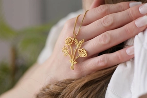 Vue détaillée d'un collier pendentif bouquet de fleurs plaqué or au design élégant