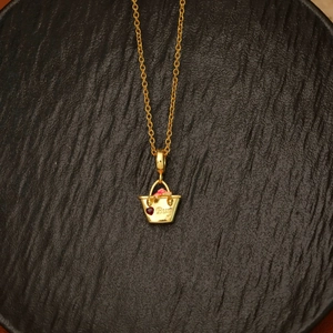 Close-up of gold shopping bag pendant with red heart and Buy engraving on black tray