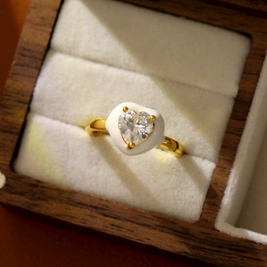 Gros plan d'une bague coeur en or avec zircon dans un coffret à bijoux en bois