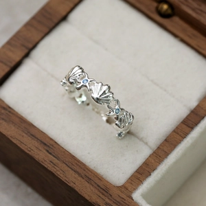 Gros plan détaillé sur une bague argentée avec motifs de coquillages et d'étoiles de mer