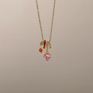 Nahaufnahme von herzförmigem rosa Kristall und Sternanhänger an goldener Kette
