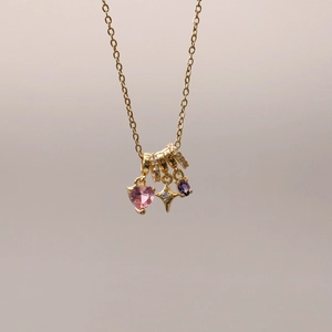 Detail der Goldkette mit Sternanhänger, rosa Herzstein und lila Edelsteinanhänger