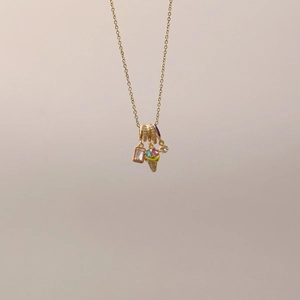 Details einer Goldkette mit Stern-, Eistüten- und rosa rechteckigen Edelsteinanhängern