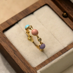 Vue macro détaillée d'une bague dorée avec perles colorées et zircon en boîte de luxe