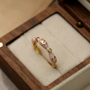 Bague dorée avec émail rose et zircon dans un écrin à bijoux en bois élégant
