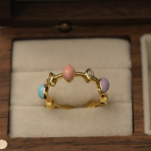 Détail d'une bague dorée ajustable avec émail coloré et zircon marquise dans son écrin