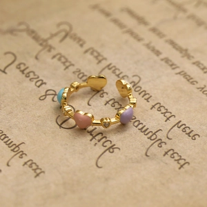 Détails de cœurs en émail coloré et zircons sur une bague ajustable dorée