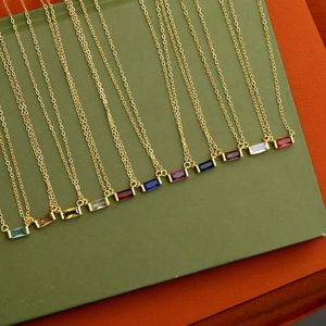 Close-up of 12 birthstone necklaces with rectangular zircons on gold chains