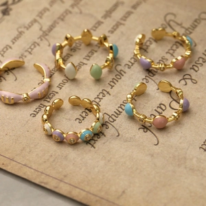 Détail de cinq bagues en émail coloré avec cœurs macarons sur papier à lettre vintage