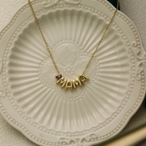 Gold mama necklace with purple gemstone on balloon style letters and cable chain