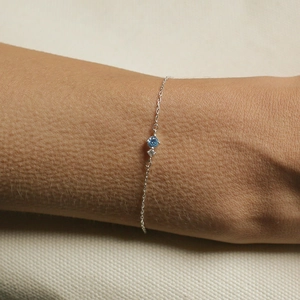 Close-up of a vintage silver bracelet with blue birthstone on a woman's wrist