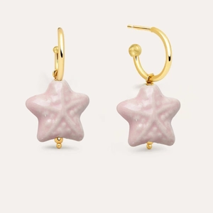 Detail of gold hoop earrings featuring pastel pink starfish pendants with textured finish