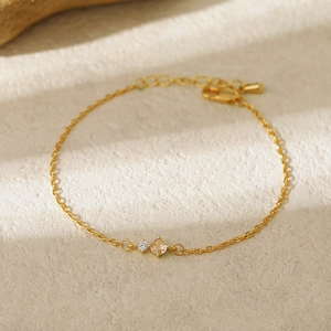 Detail view of gold birthstone bracelet with round champagne and clear crystals