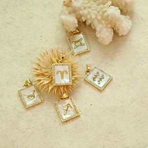 Detailaufnahme der Sternzeichen-Anhänger aus Perlmutt mit Gold und Zirkonia-Besatz