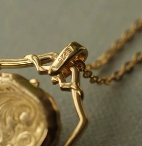Vue macro du poinçon S925 sur médaillon doré avec des motifs en relief vintage