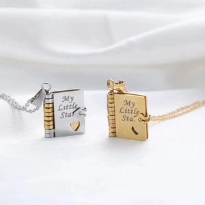 Close-up of gold and silver book-shaped lockets with My Little Star engraving on silk