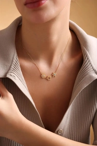Detailed shot of golden bouquet necklace with colored gems on model neck