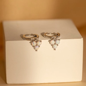 Detail view of 18K gold plated opal earrings on a white geometric stone display
